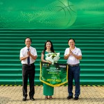 Ông Huỳnh Trọng Khải - Chủ tịch Liên đoàn Bóng rổ TPHCM (bên trái) và Ông Nguyễn Nam Nhân – Phó giám đốc Sở Văn hóa và Thể thao TPHCM (bên phải) trao hoa và cờ lưu niệm cho bà Bà Lê Bùi.