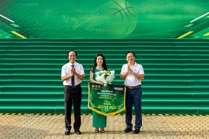 Ông Huỳnh Trọng Khải - Chủ tịch Liên đoàn Bóng rổ TPHCM (bên trái) và Ông Nguyễn Nam Nhân – Phó giám đốc Sở Văn hóa và Thể thao TPHCM (bên phải) trao hoa và cờ lưu niệm cho bà Bà Lê Bùi.