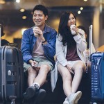 Two asian tourists with suitcases spending happy time in cafe